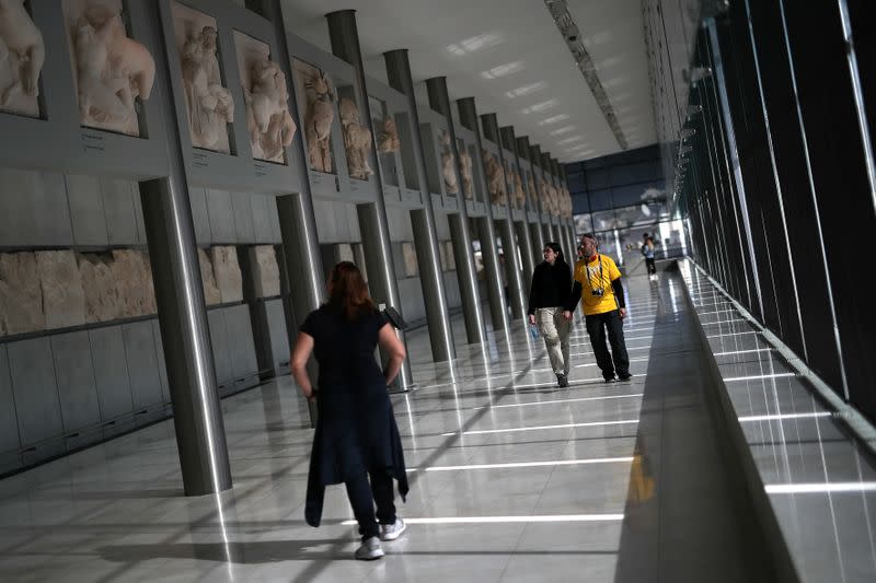 People visit the Parthenon Gallery of the Acropolis Museum, where original sculptures and plaster cast copies of the frieze of the Parthenon temple are exhibited, in Athens