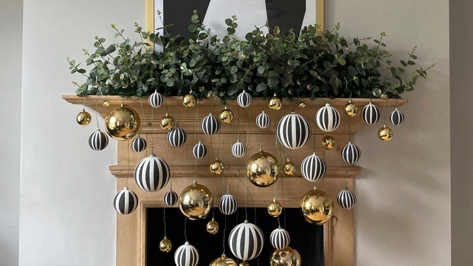 a fireplace strung with christmas ornaments