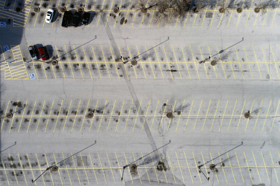 The parking outside Saint Louis Galleria mall is virtually empty Thursday, March 26, 2020, in Richmond Heights, Mo. The mall has been closed to the public, with only a few restaurants allowed to stay open for to go orders, due to the coronavirus pandemic. (AP Photo/Jeff Roberson)