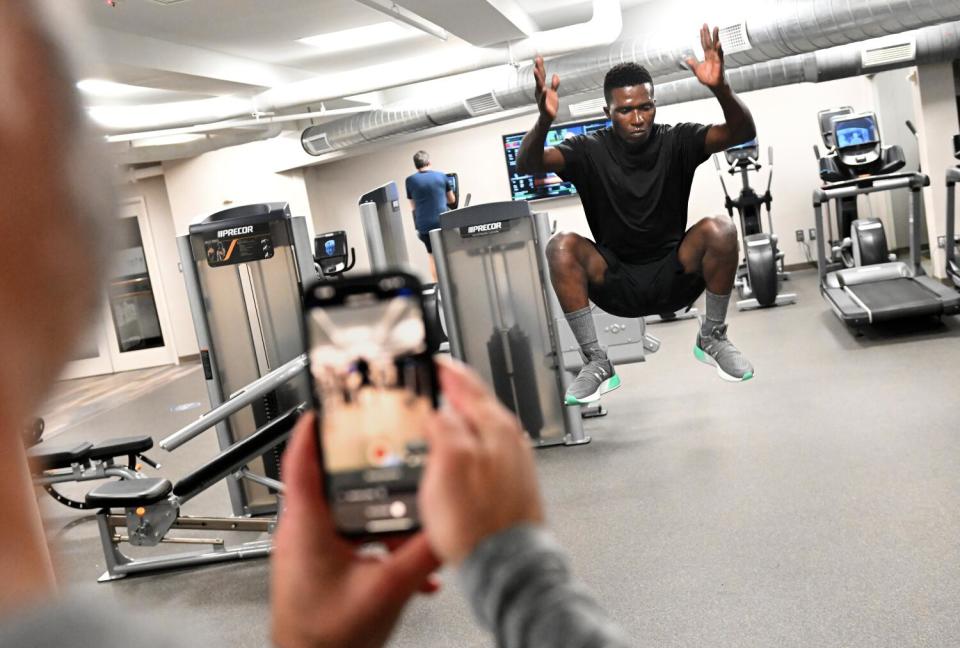 Frederick Keys player Dennis Kasumba is filmed by MLB Draft League executive director Sean Campbell in a hotel gym.