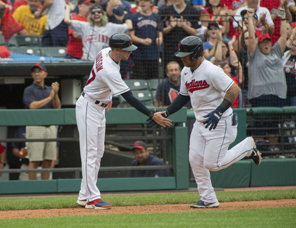 Cleveland Indians' Harold Ramirez, right, is greeted by third base coach Kyle Hudson after hitting a solo home run off Chicago White Sox relief pitcher Craig Kimbrel during the eighth inning of a baseball game in Cleveland, Sunday, Sept. 26, 2021. (AP Photo/Phil Long)