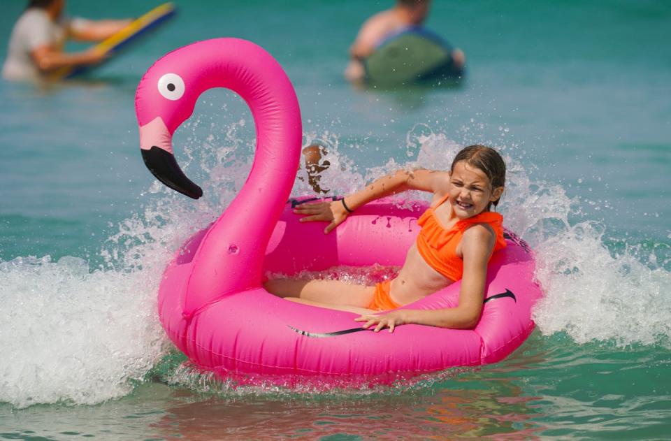 ]A young girl rides her inflatable pelican in the sea at Fistral Beach (Getty Images)