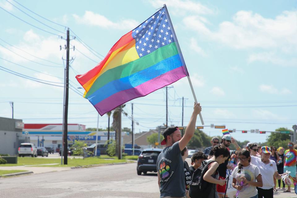 Jonathan Dale Swindle, president of Pride Corpus Christi, holds a rainbow flag to lead the way of the organization's second annual Pet Paw-rade at St. Paul's United Church of Christi Saturday, June 11, 2022.