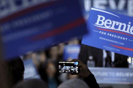 A supporter of U.S. Democratic presidential candidate Bernie Sanders takes a photo of the candidate as he speaks at a campaign rally in Des Moines, Iowa January 31, 2016. REUTERS/Mark Kauzlarich