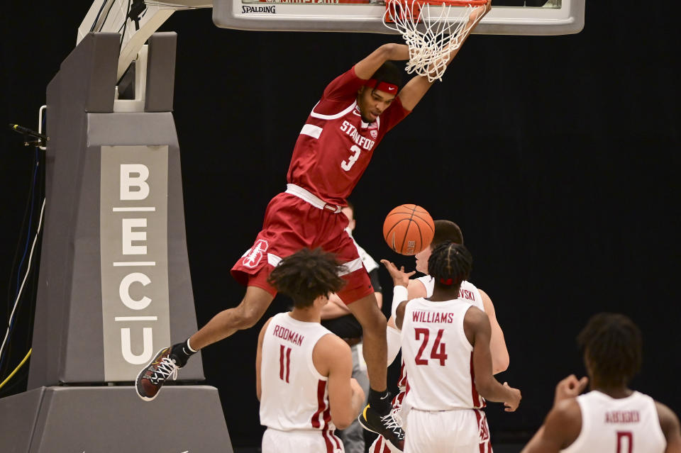 Stanford forward Ziaire Williams (3) hangs on the rim after dunking the ball as Washington State forward DJ Rodman (11) and guard Noah Williams (24) look on during the first half of an NCAA college basketball game, Saturday, Feb. 20, 2021, in Pullman, Wash. (AP Photo/Pete Caster)