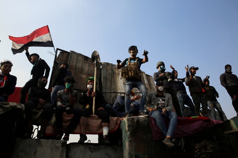 Demonstrators gesture as they take part in the ongoing anti-government protests at Ahrar bridge in Baghdad