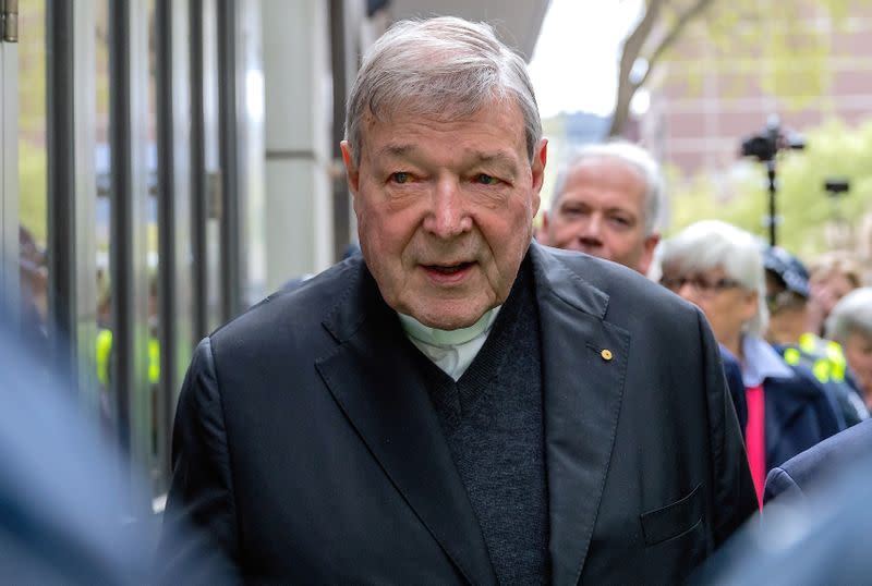 FILE PHOTO - Vatican Treasurer Cardinal George Pell is surrounded by Australian police as he leaves the Melbourne Magistrates Court in Australia