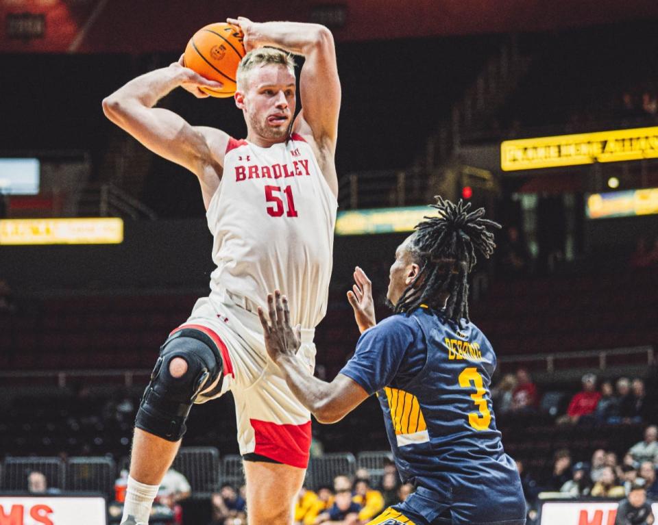 Bradley 6-foot-10 center Rienk Mast made his season debut, as Merrimack 6-2 guard Mykel Derring tried to stop him during the Braves 83-41 blowout win at Carver Arena on Saturday, Nov. 26, 2022.