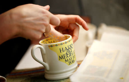 A worker adds transfers to mugs commemorating the wedding of Britain's Prince Harry and Meghan Markle at the Emma Bridgewater Factory, in Hanley, Stoke-on-Trent, Britain March 28, 2018. REUTERS/Carl Recine