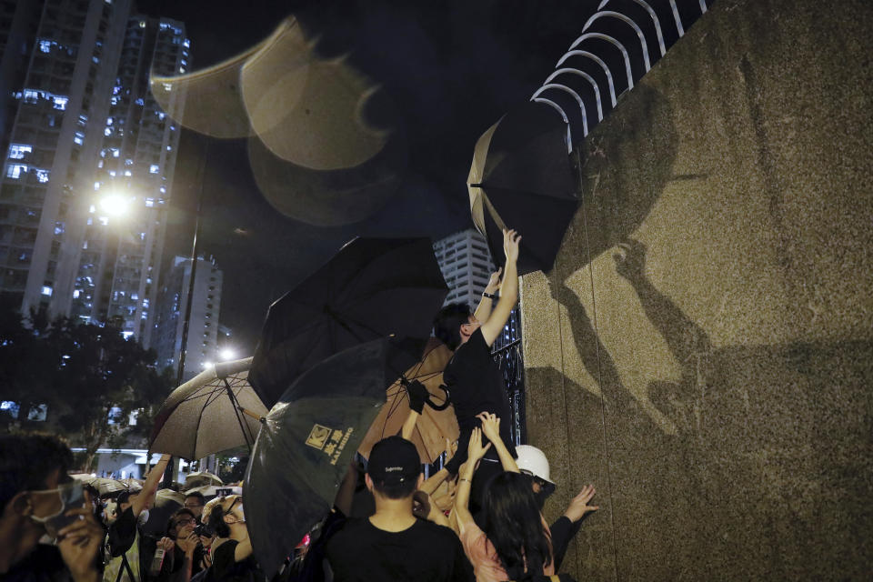 Protesters use an umbrella to block a surveillance camera at Kwai Chung police station in Hong Kong, Wednesday, July 31, 2019. Protesters clashed with police again in Hong Kong on Tuesday night after reports that some of their detained colleagues would be charged with the relatively serious charge of rioting. (AP Photo/Vincent Yu)