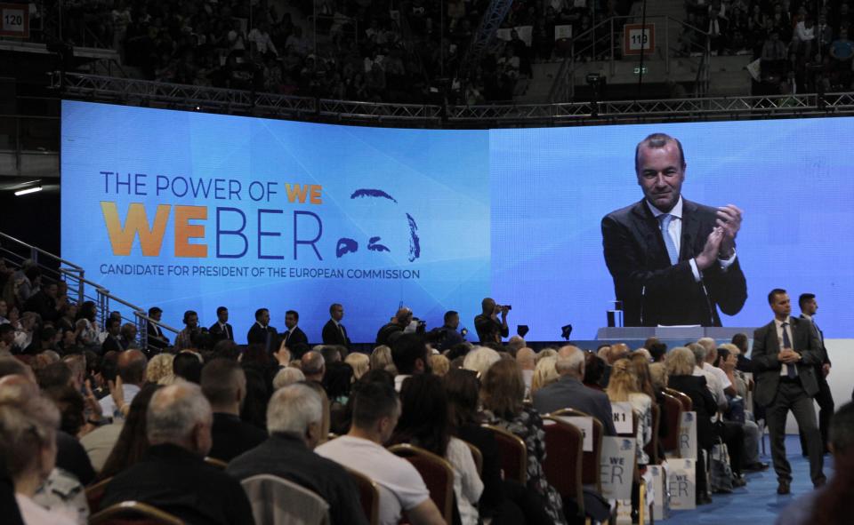 Germany's Manfred Weber of the European People's Party, on the monitor, applauds after addressing the audience at the Bulgaria's GERB ruling Party rally in Sofia, Bulgaria, Sunday, May 19, 2019. The rally comes days before more than 400 million Europeans from 28 countries will head to the polls to choose lawmakers to represent them at the European Parliament for the next five years. (AP Photo/Valentina Petrova)