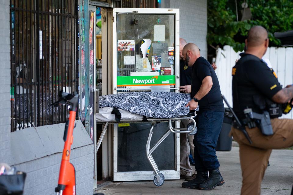 The victim's body from a homicide that took place at Time Saver Food & Gas is brought out of the store covered with a cloth, on a stretcher and placed into the back of a van Monday, July 31, 2023.