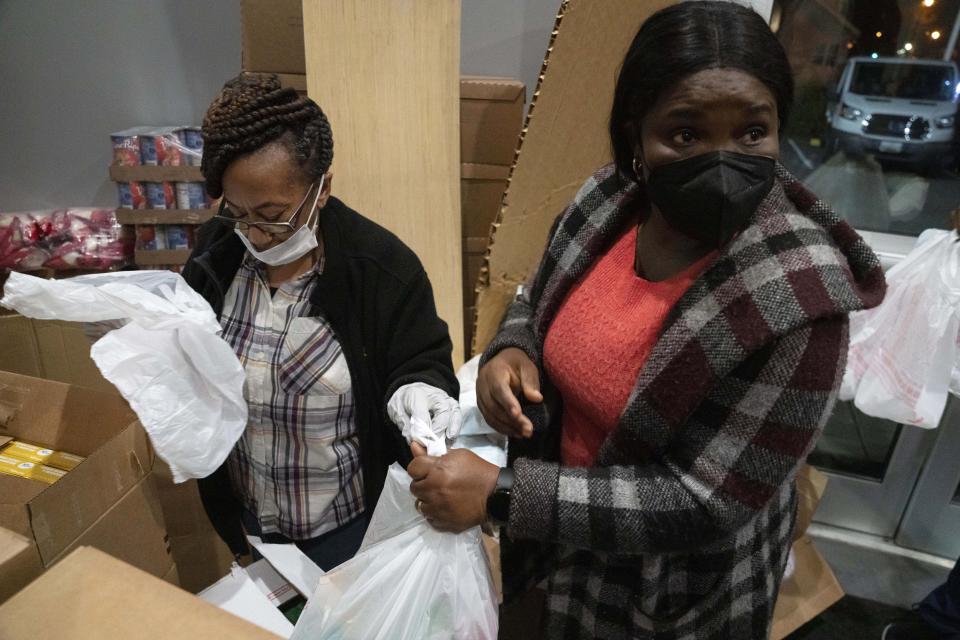 Church volunteers Muriel Francis, of Washington, left, and Bola Fawibe, pack bags of foods for Thanksgiving during an annual Thanksgiving food giveaway at The Redeemed Christian Church of God New Wine Assembly, Tuesday, Nov. 22, 2022, in Washington. (AP Photo/Jacquelyn Martin)
