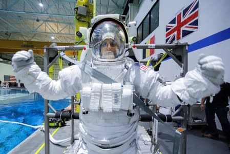 NASA Commercial Crew astronaut Sunita Williams is helped to get into her space suit at NASA's Neutral Buoyancy Laboratory (NBL) training facility near the Johnson Space Center in Houston