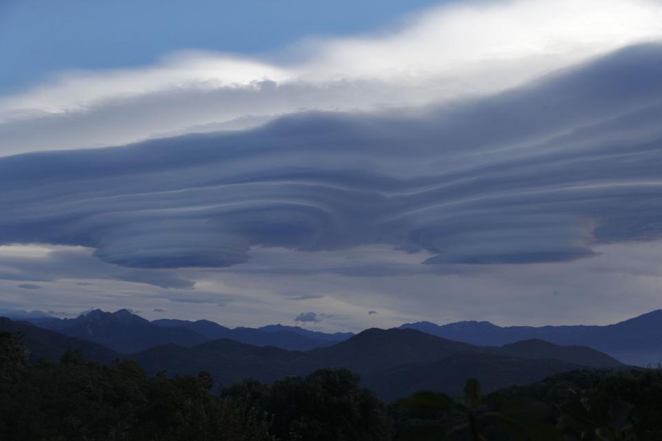 A photo taken in Cognocoli-Monticchi on the French Mediterranean island of Corsica on Nov. 14, 2023, shows lenticular clouds above Corsican mountains. A new study released Nov. 15, 2023, found evidence of microplastics in clouds in China.