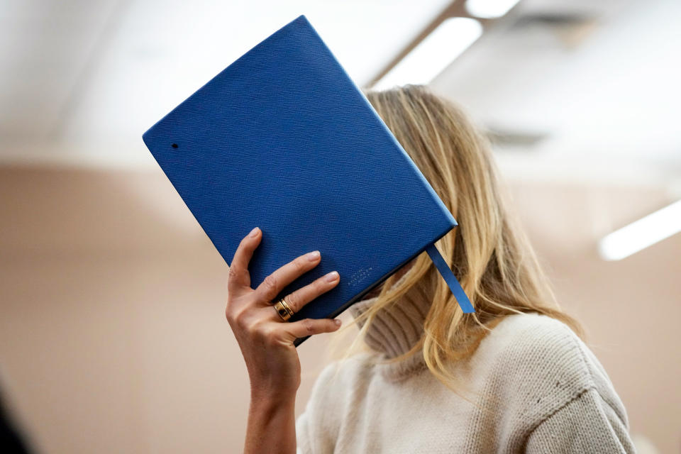 Paltrow shields her face with a $250 Smythson blue notebook as she exits the courtroom on March 21, 2023, in Park City, Utah.