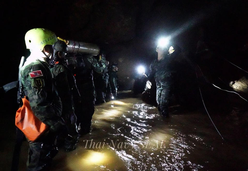 Thai military personnel carrying equipment inside the cave complex. Source: AAP