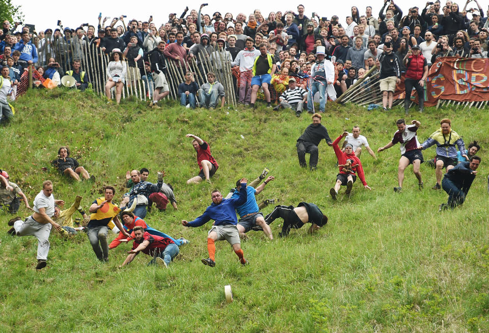 <p>Competitors take part in the annual, unofficial cheese-rolling race at Cooper’s Hill in Brockworth, England, on May 30, 2016. Runners have competed, chasing a round of cheese down the 200 yard, one-in-three gradient hill in Brockworth, annually since the early 1800s. (Joe Giddens/PA via AP) </p>