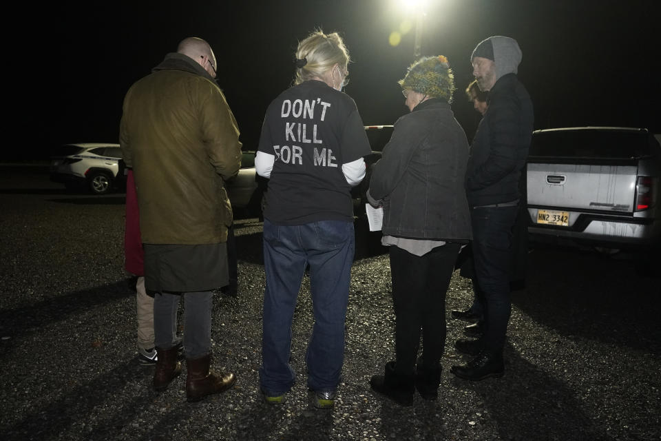 Sheila O'Flaherty, center, wears her opposition to the death penalty T-shirt, as she and other opponents participate in a vigil for inmate Thomas Edwin Loden Jr., outside the Mississippi State Penitentiary in Parchman, Miss., Wednesday evening, Dec. 14, 2022. Loden, who pleaded guilty to raping and killing a 16-year-old girl, was put to death by lethal injection on Wednesday, becoming the second inmate executed in the state in 10 years. (AP Photo/Rogelio V. Solis)