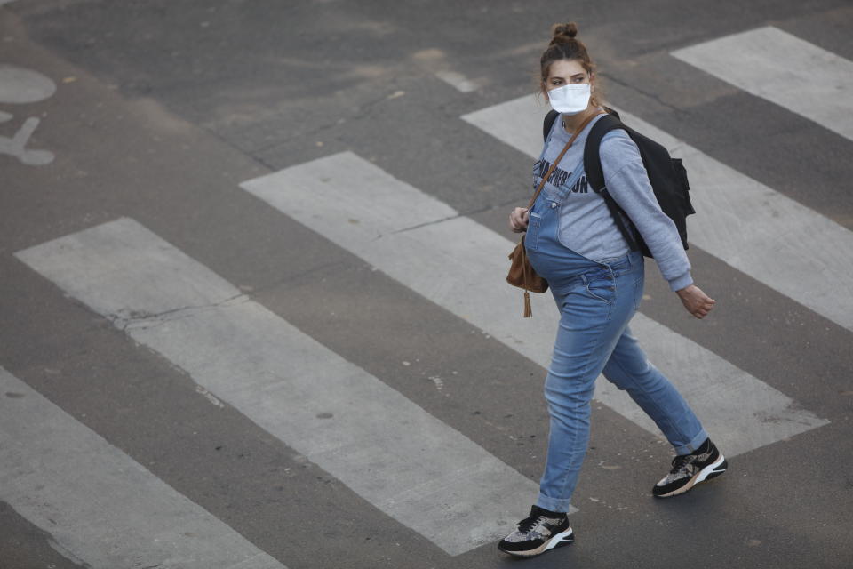 A pregnant women with a protective mask walks on the street in Paris, on April 8, 2020, during the lockdown in France to attempt to halt the spread of the novel coronavirus COVID-19.   (Photo by Mehdi Taamallah/NurPhoto via Getty Images)