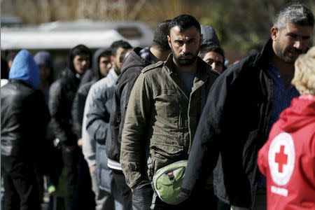 Refugees and migrants line up for a goods distribution by the Hellenic Red Cross outside a passenger terminal used as shelter at the port of Piraeus, near Athens, Greece, March 4, 2016. REUTERS/Alkis Konstantinidis