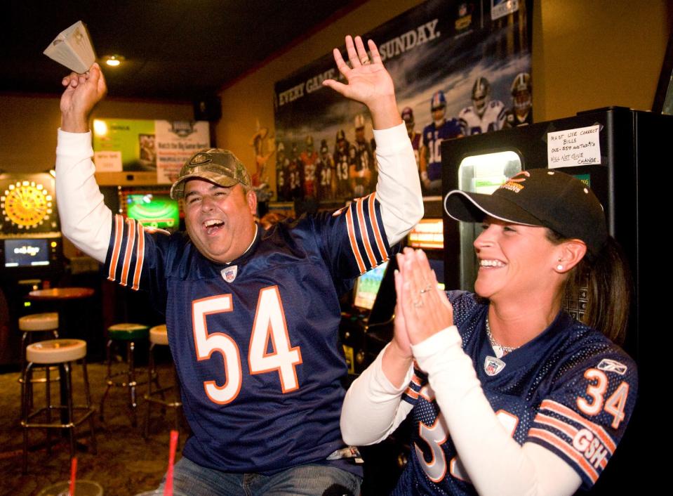 Scott and Jenny Sheets celebrate their team's first touchdown on Sunday while watching the game at the bar Johnny Vig's in Peoria.