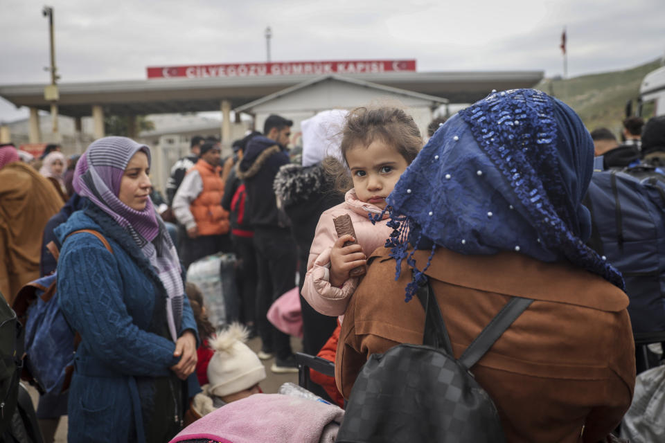 Syrians wait to cross into Syria from Turkey at the Cilvegozu border gate, near the town of Antakya, southeastern Turkey, Tuesday, Feb. 21, 2023. The death toll in Turkey and Syria rose to eight in a new and powerful earthquake that struck two weeks after a devastating temblor killed nearly 45,000 people, authorities and media said Tuesday. (AP Photo/Unal Cam)