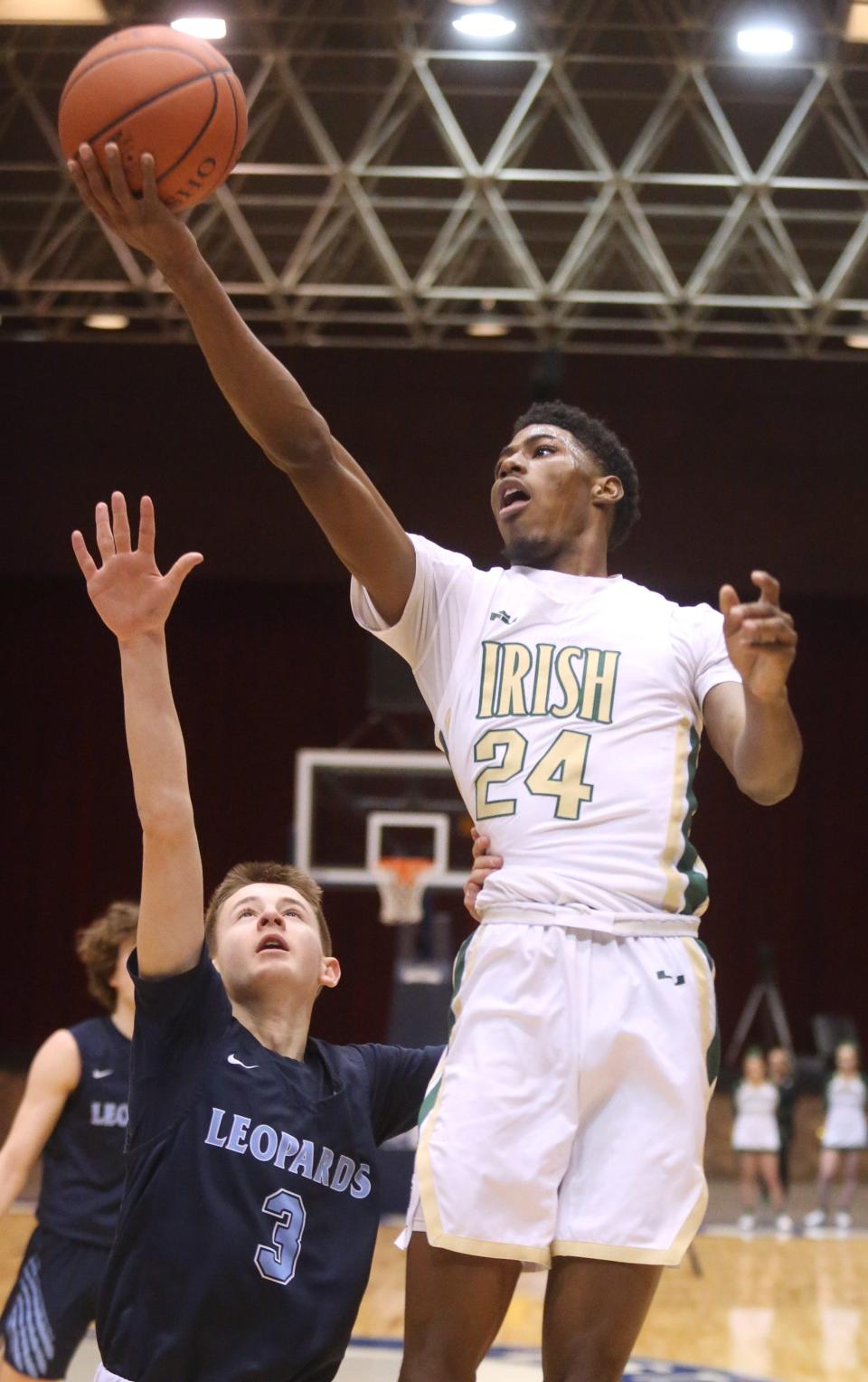 Sencire Harris, 24, of Akron St. Vincent-St. Mary goes to the basket while being guarded by Beau Siegfried, 3, of Louisville during their DII regional final at the Canton Memorial Civic Center on Saturday, March 12, 2022.