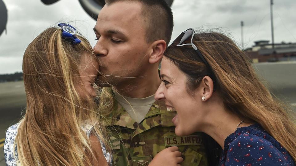 Tech. Sgt. Jason Fatjo, a 14th Airlift Squadron loadmaster, embraces his family after returning from a deployment at Joint Base Charleston, S.C., Aug. 8, 2017. (Senior Airman Christian Sullivan/Air Force)