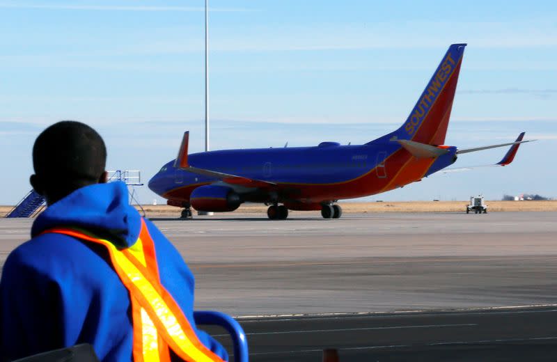 FILE PHOTO: A luggage handler watches a departing Southwest Airlines jet at Denver International Airport in Denver