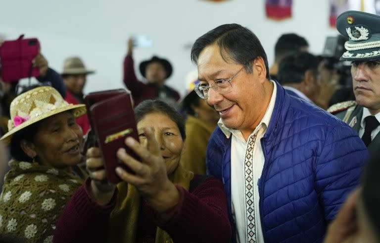 El presidente boliviano, Luis Arce, se toma una selfie con un partidario después de asistir a una asamblea de trabajadores agrícolas de la Confederación de Pueblos Interculturales de Bolivia, en La Paz, Bolivia, el martes 3 de octubre. (AP/Juan Karita)