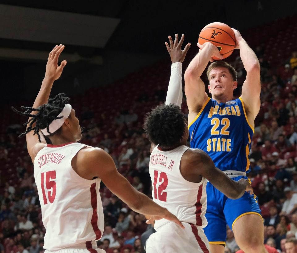 Nov 6, 2023; Tuscaloosa, Alabama, USA; Morehead State guard Riley Minix (22) takes a shot against Alabama guard Latrell Wrightsell Jr. (12) and Alabama forward Jarin Stevenson (15) at Coleman Coliseum. Mandatory Credit: Gary Cosby Jr.-USA TODAY Sports