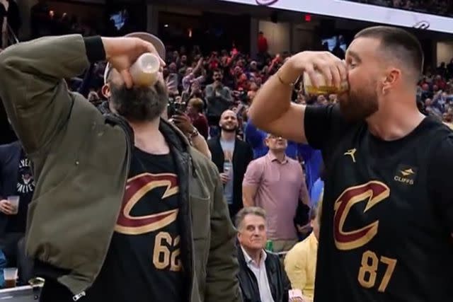 <p>cleveland Cavaliers/x</p> Jason Kelce and Travis Kelce drink beers served by the Cavs' mascot Moondog