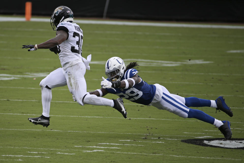 Jacksonville Jaguars running back James Robinson (30) slips past Indianapolis Colts free safety Malik Hooker for a gain during the first half of an NFL football game, Sunday, Sept. 13, 2020, in Jacksonville, Fla. (AP Photo/Stephen B. Morton)