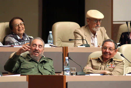 President Fidel Castro (L, front) gestures next to his brother Raul (R, front) as Vilma Espin (L, rear) laughs next to Roberto Fernandez Retamar, president of the Cuban publisher Casa de las Americas, during a meeting of Cuba's National Assembly in Havana, October 25, 2003. REUTERS/Stringer/Files