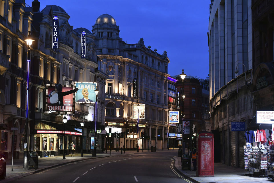 View looking up an empty Shaftesbury Avenue around what would normally be theatre opening time, as London's theatreland goes dark, the day after Prime Minister Boris Johnson ordered public meeting places like theatres, pubs, and restaurants across the country to close in unprecedented measures to limit the spread of the coronavirus outbreak. Saturday March 21, 2020. For some people the COVID-19 coronavirus causes mild or moderate symptoms, but for others it causes severe illness. (Dominic Lipinski / PA via AP)