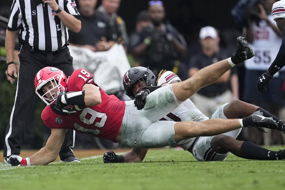 Georgia tight end Brock Bowers (19) is taken down by South Carolina defensive back DQ Smith (1) after a catch during the first half of an NCAA college football game Saturday, Sept. 16, 2023, Ga. (AP Photo/John Bazemore)