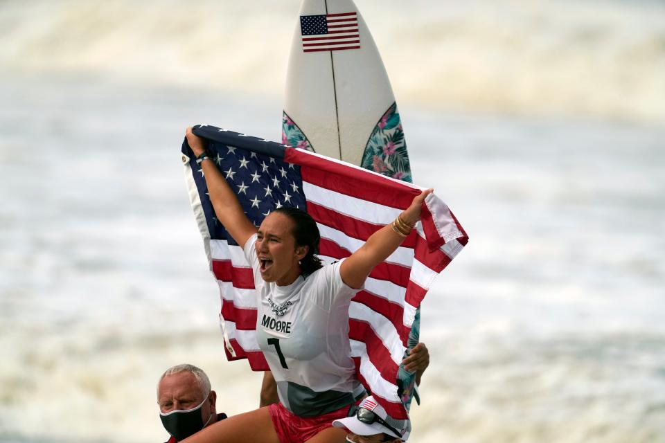 Carissa Moore celebrates after winning the gold medal in the women's surfing competition.