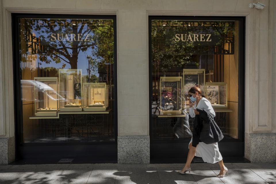 A woman walks past a jewelry store in the upmarket neighborhood of Salamanca in Madrid, Spain, Monday, Sept. 28, 2020. The extended region around Madrid, comprising a population of 6.6 million, is struggling to control coronavirus outbreaks. Heightened restrictions in some of Madrid's working-class neighborhoods brought a heated debate over the prevalence of inequality in Spain. (AP Photo/Bernat Armangue)