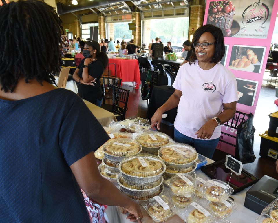 Aug 27, 2022; Tuscaloosa, AL, USA; Sherry Morrow talks with a patron in her A Tasty Treat booth at the Farmer's Market Saturday, Aug. 27, 2022, at the Tuscaloosa River Market. Mandatory Credit: Gary Cosby Jr.-Tuscaloosa News