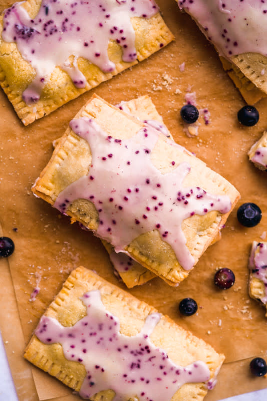 <p>The Fit Peach</p><p>Your favorite childhood treat just got even better! These pop tarts have a perfectly flaky, golden crust stuffed with a deliciously sweet blueberry filling and drizzled with an easy blueberry infused icing. Vegan, gluten-free, paleo-friendly, and dairy free.</p><p><strong>Get the Recipe: <a href="https://www.thefitpeach.com/blog/healthy-homemade-blueberry-pop-tart-recipe/" rel="nofollow noopener" target="_blank" data-ylk="slk:Homemade Blueberry Pop Tarts;elm:context_link;itc:0;sec:content-canvas" class="link "><em>Homemade Blueberry Pop Tarts</em></a></strong></p>