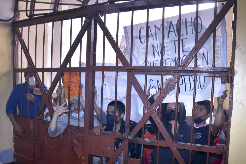 Inmates hold a sign with a message that reads in Spanish: "Camacho, we do not want you here in San Pedro", during a protest against the possible transfer of Santa Cruz Gov. Luis Fernando Camacho to the detention facility in La Paz, Bolivia, Thursday, Dec. 29, 2022. Police on Wednesday detained Camacho, the main opposition leader in Bolivia, near his Santa Cruz home. The Chief Prosecutor’s Office said Camacho was detained as part of a case in which he is accused of leading what the government characterizes as a coup in 2019. (AP Photo/Jose Lavayen)