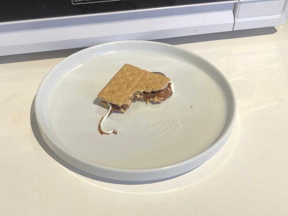 microwave smore with a bite taking out of it on a white plate