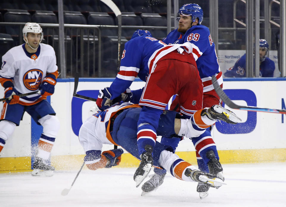 New York Rangers' Jacob Trouba (8) checks New York Islanders' Mathew Barzal during the third period of an NHL hockey game Saturday, Jan. 16, 2021, in New York. (Bruce Bennett/Pool Photo via AP)