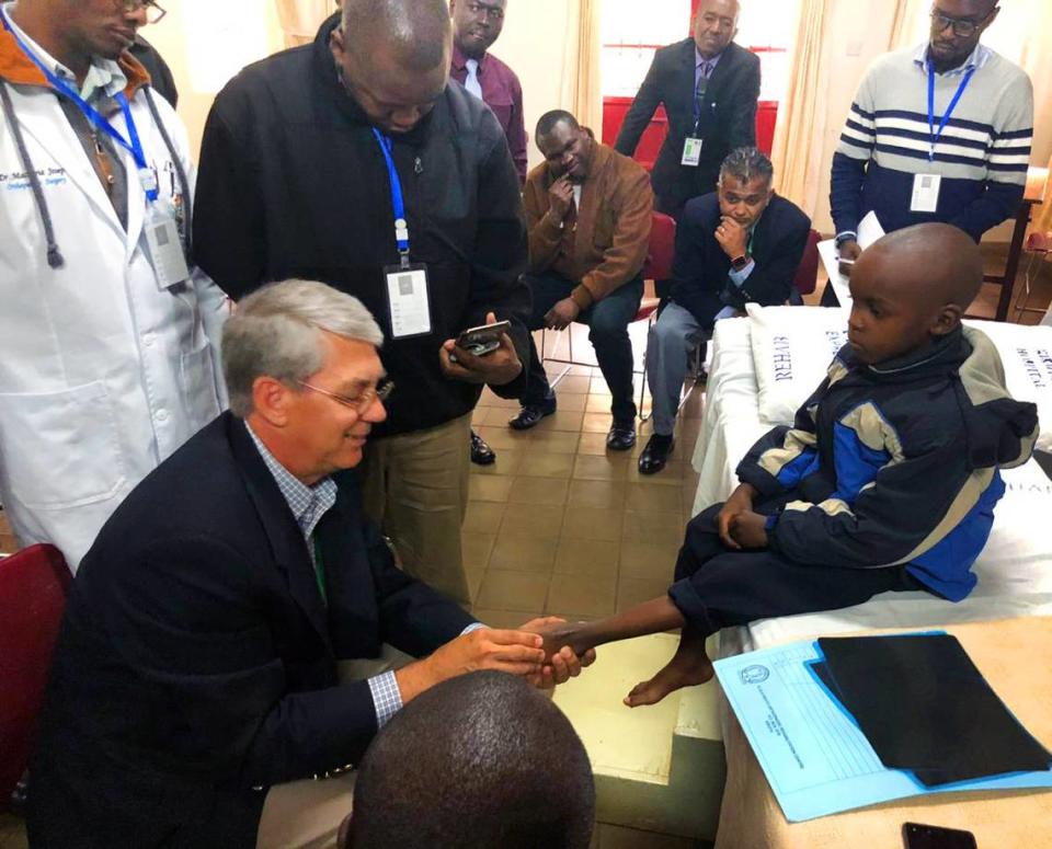 Dr. Leland McCluskey, an orthopedic surgeon at St. Francis-Emory Healthcare in Columbus, examines a patient being treated in the Steps2Walk program in Kenya.
