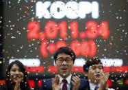 Employees of the Korea Exchange pose in front of the final stock price index during a photo opportunity for the media at the ceremonial closing event of the 2013 stock market at the Korea Exchange (KRX) in Seoul December 30, 2013. REUTERS/Kim Hong-Ji