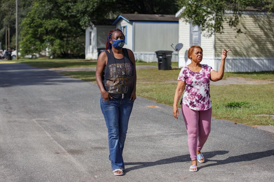 Jasmine Booker, left, and Gloria Ogden, both residents of what was formerly known as Meadows Mobile Home Park, walk through their neighborhood Thursday, Nov. 4, 2021. The property is under new management and has been renamed Florida Sun Estates. Many residents were forced to move out when the new owner significantly increased rental prices. 