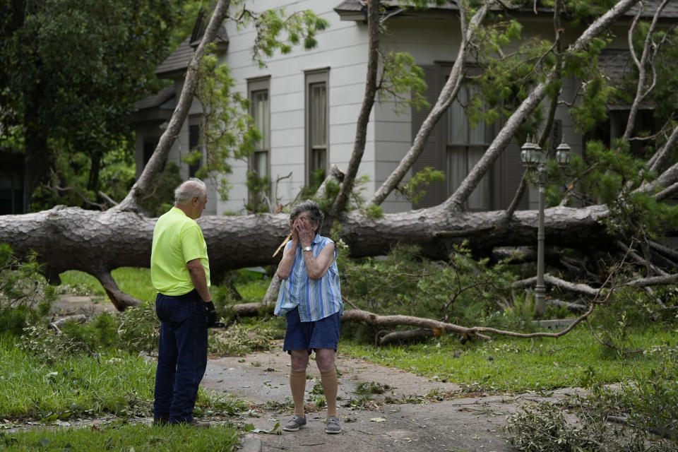 Jackie Jecmenek, a la derecha, habla con Bobby Head, un trabajador de la ciudad, frente a la casa de su vecino tras el paso de Beryl, el lunes 8 de julio de 2024, en Bay City, Texas. (AP Foto/Eric Gay)