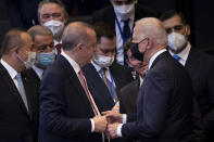 Turkey's President Recep Tayyip Erdogan, center left, greets U.S. President Joe Biden, center right, during a plenary session during a NATO summit at NATO headquarters in Brussels, Monday, June 14, 2021. U.S. President Joe Biden is taking part in his first NATO summit, where the 30-nation alliance hopes to reaffirm its unity and discuss increasingly tense relations with China and Russia, as the organization pulls its troops out after 18 years in Afghanistan. (Brendan Smialowski, Pool via AP)