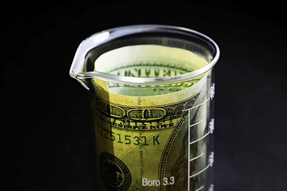 A hundred dollar bill inside a small beaker.